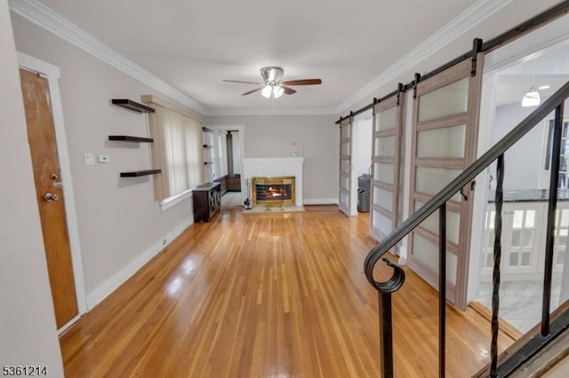 53 Elliot Pl, East Orange City, NJ 07018 - unfurnished living room with a barn door, a ceiling fan, wood finished floors, baseboards, and crown molding