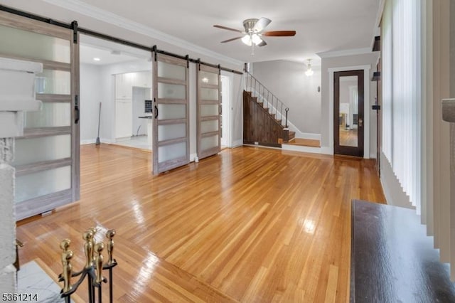 53 Elliot Pl, East Orange City, NJ 07018 - unfurnished living room featuring a barn door, ceiling fan, stairs, wood finished floors, and ornamental molding