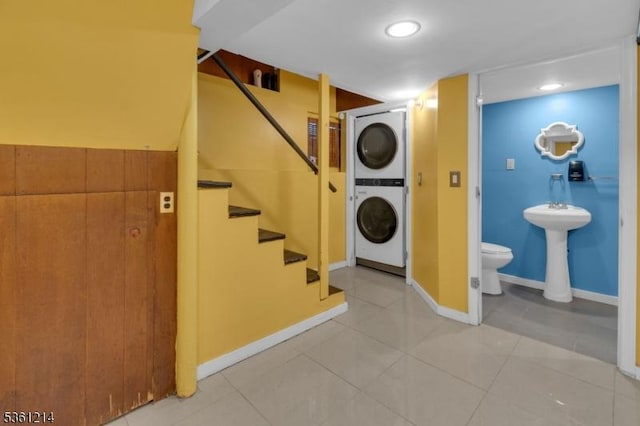 53 Elliot Pl, East Orange City, NJ 07018 - laundry room featuring stacked washer / drying machine, light tile patterned floors, and baseboards