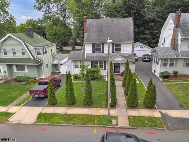 53 Elliot Pl, East Orange City, NJ 07018 - view of front facade featuring driveway, a front lawn, and a chimney