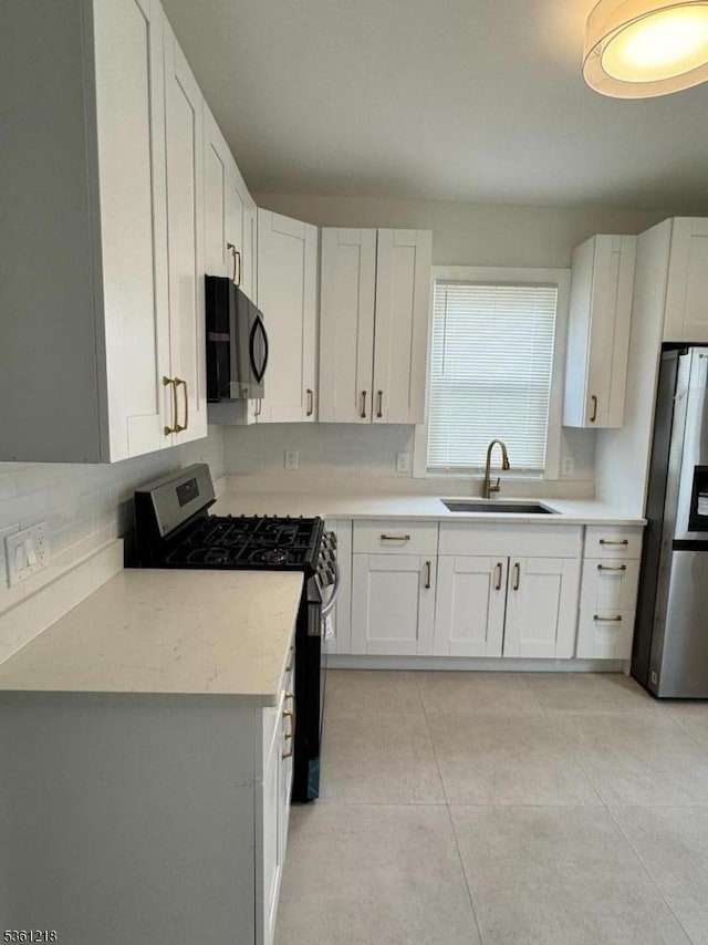 50 Willoughby St, Newark City, NJ 07112 - kitchen featuring appliances with stainless steel finishes, a sink, backsplash, white cabinetry, and light countertops