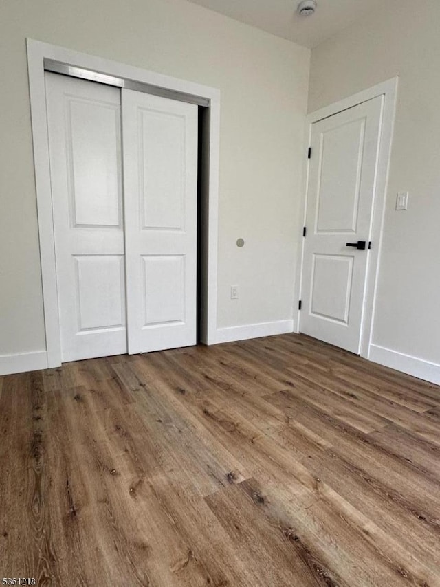 50 Willoughby St, Newark City, NJ 07112 - unfurnished bedroom featuring wood finished floors, a closet, and baseboards