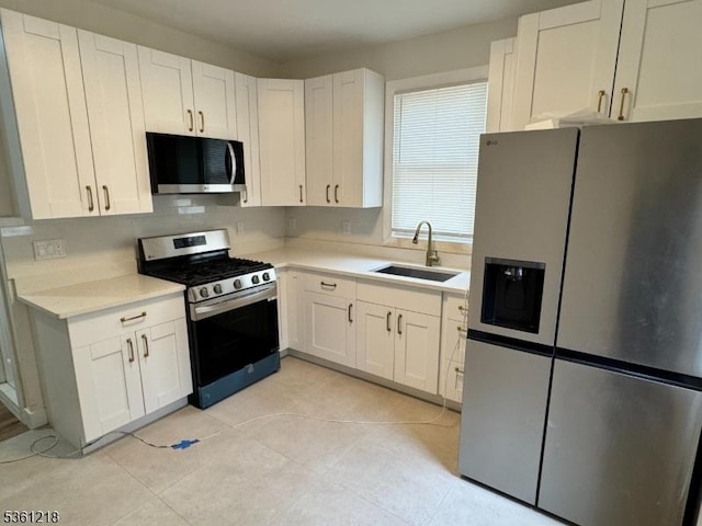 50 Willoughby St, Newark City, NJ 07112 - kitchen featuring appliances with stainless steel finishes, a sink, light countertops, white cabinetry, and light tile patterned flooring