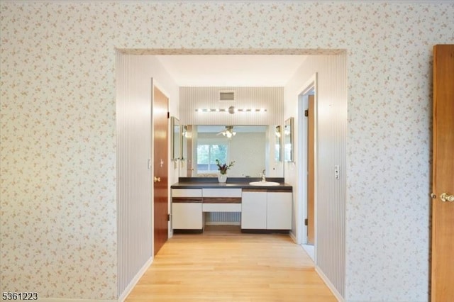 14 Highpoint Unit 14, Cedar Grove Twp, NJ 07009 - corridor with light wood-style flooring, wallpapered walls, and a sink