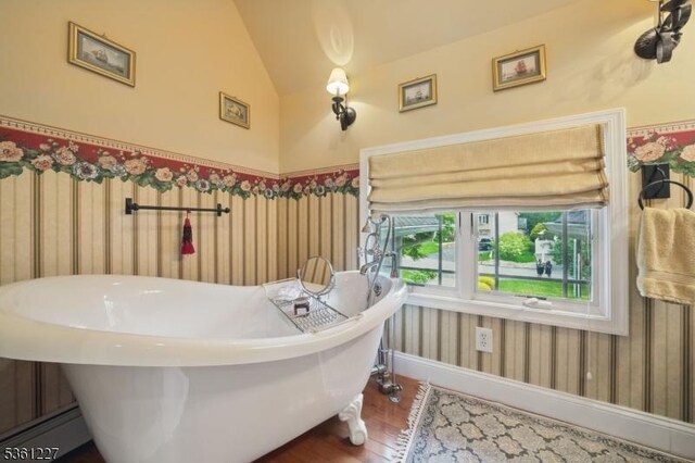 10 Fawn Ter, Jefferson Twp, NJ 07849 - bathroom featuring wood finished floors, a soaking tub, lofted ceiling, and baseboards