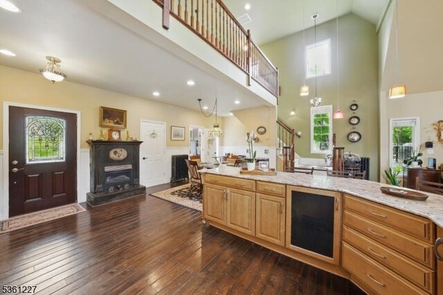 10 Fawn Ter, Jefferson Twp, NJ 07849 - kitchen featuring a high ceiling, light stone countertops, dark wood-style floors, hanging light fixtures, and wine cooler