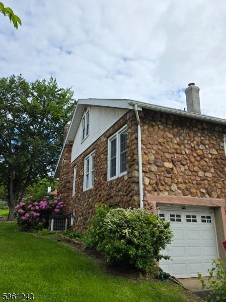 126 Park Ave, Lopatcong Twp, NJ 08865 - view of property exterior featuring stone siding, stucco siding, a chimney, central AC, and a yard