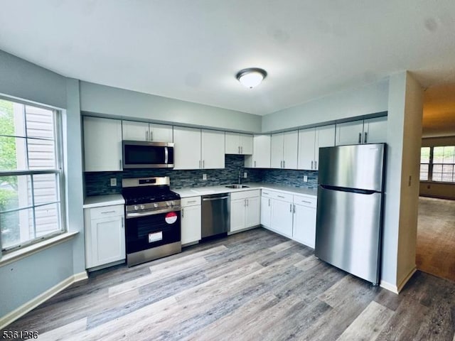 123 Pinehurst Dr, Washington Twp, NJ 07882 - kitchen with stainless steel appliances, light countertops, light wood finished floors, and tasteful backsplash