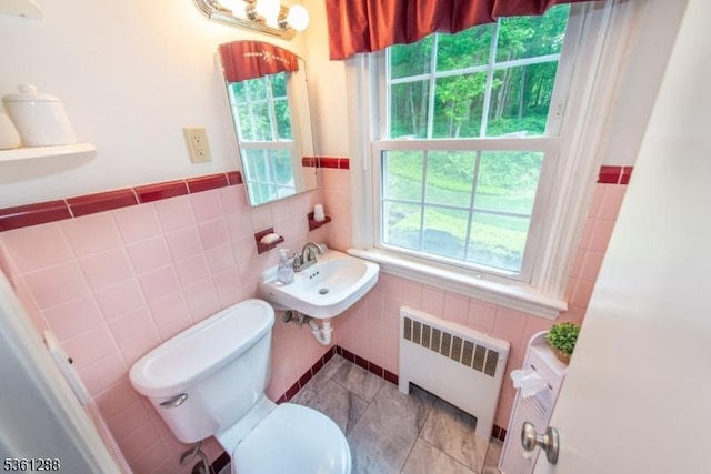24 W Windy Bush Ln, Sparta Twp, NJ 07871 - bathroom with radiator, toilet, a sink, tile walls, and wainscoting