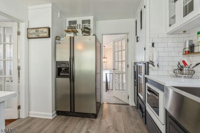 1 Hollywood Dr, Woodbridge Twp, NJ 07095 - kitchen with stainless steel refrigerator with ice dispenser, light wood-type flooring, backsplash, and white cabinetry