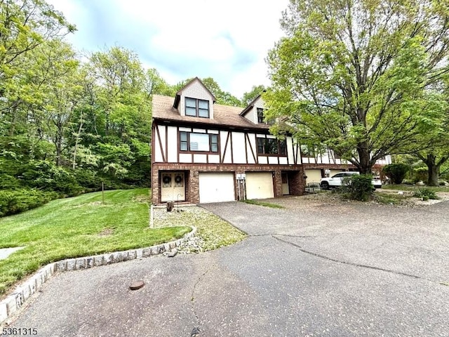 146 Garside Ave Unit 5, Wayne Twp, NJ 07470 - tudor house featuring an attached garage, driveway, brick siding, and a front lawn