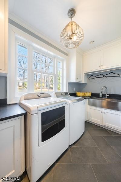 10 Rowan Rd, Summit City, NJ 07901 - laundry area featuring washing machine and dryer, cabinet space, dark tile patterned flooring, and ornamental molding