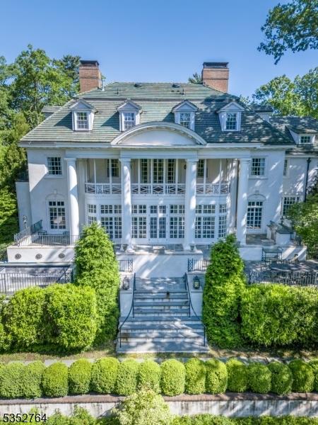 10 Rowan Rd, Summit City, NJ 07901 - back of property with a chimney, stairway, stucco siding, and a high end roof