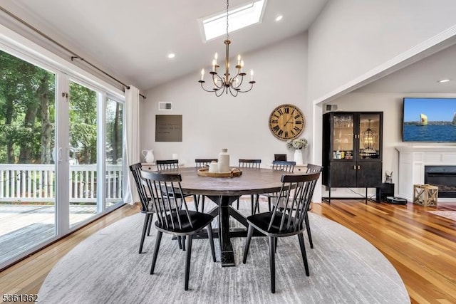 86 Belmont Ave, Cranford Twp, NJ 07016 - dining room with a chandelier, a skylight, light wood-type flooring, a glass covered fireplace, and high vaulted ceiling