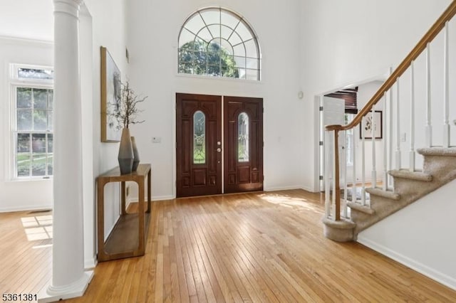 25 Castle Ct, Randolph Twp, NJ 07869 - entrance foyer featuring light wood-style floors, stairway, decorative columns, baseboards, and a towering ceiling