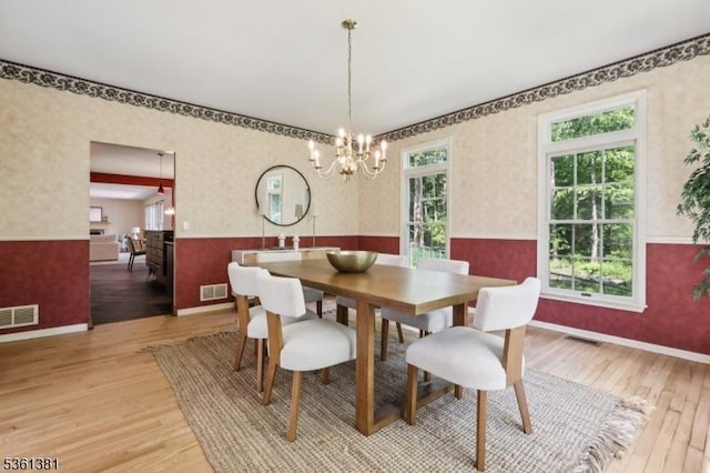 25 Castle Ct, Randolph Twp, NJ 07869 - dining space featuring wallpapered walls, a wainscoted wall, light wood finished floors, plenty of natural light, and a chandelier