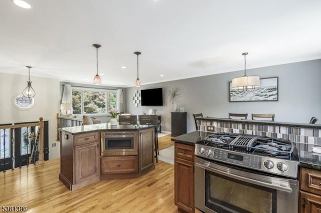 22 Messig Rd, Clinton Town, NJ 08809 - kitchen with stainless steel appliances, light wood-style floors, dark stone counters, hanging light fixtures, and a center island