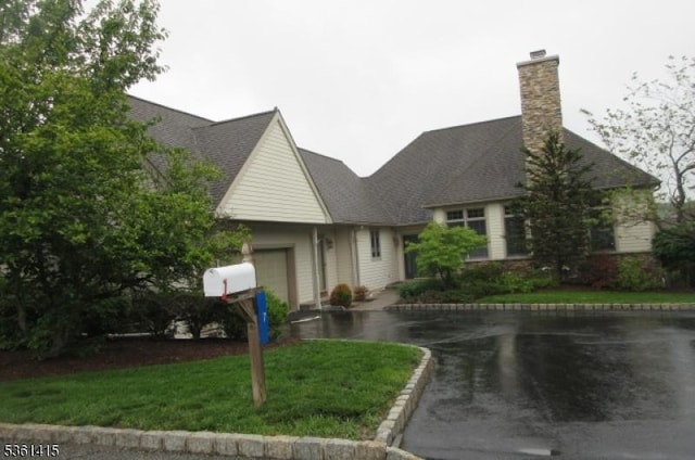 7 Troon Dr, Fredon Twp, NJ 07860 - view of front facade featuring an attached garage, a chimney, and a front yard