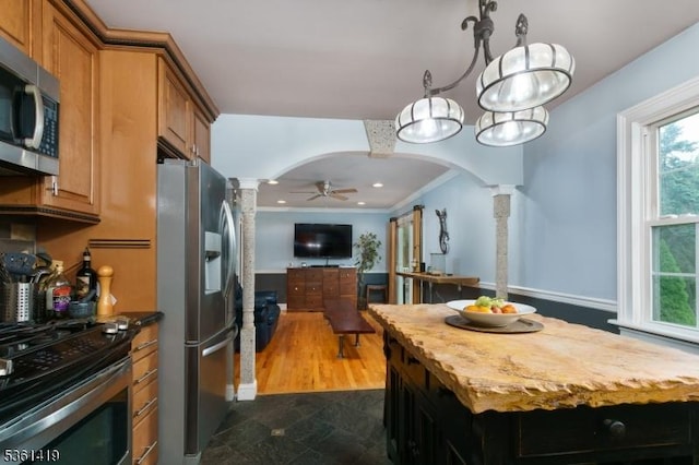 50 Skillman Rd, Montgomery Twp, NJ 08558 - kitchen featuring appliances with stainless steel finishes, decorative columns, arched walkways, brown cabinetry, and open floor plan