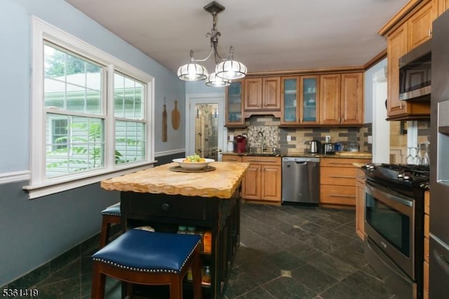 50 Skillman Rd, Montgomery Twp, NJ 08558 - kitchen featuring stainless steel appliances, a chandelier, backsplash, brown cabinets, and glass insert cabinets