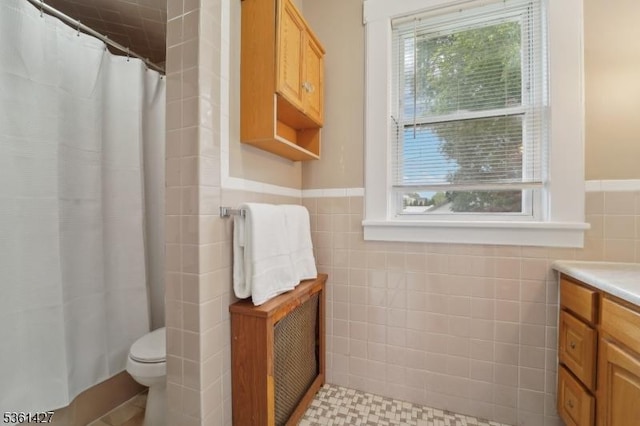 30 Market St, Garfield City, NJ 07026 - full bathroom featuring tile walls, toilet, vanity, a shower with shower curtain, and a wainscoted wall