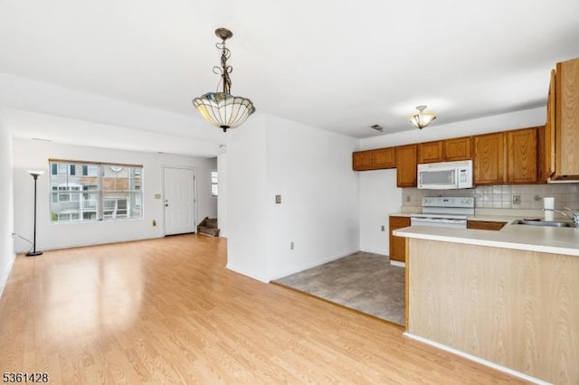 239 40th St Unit 7, Irvington Twp, NJ 07111 - kitchen with white appliances, a sink, light countertops, light wood finished floors, and tasteful backsplash