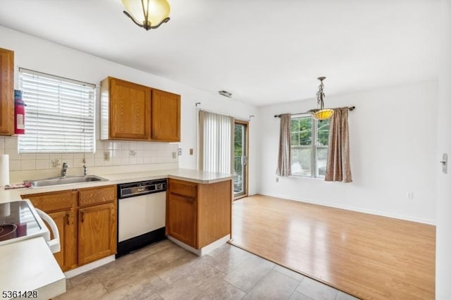 239 40th St Unit 7, Irvington Twp, NJ 07111 - kitchen with white dishwasher, a peninsula, tasteful backsplash, light countertops, and a sink
