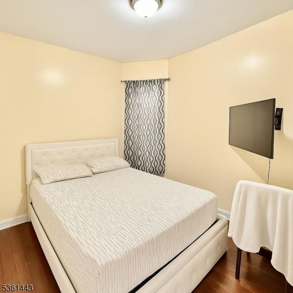 276 5th Ave, Paterson City, NJ 07524 - bedroom featuring dark wood finished floors and baseboards