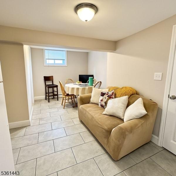 276 5th Ave, Paterson City, NJ 07524 - living room with light tile patterned floors and baseboards
