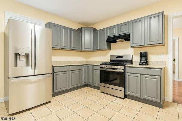 276 5th Ave, Paterson City, NJ 07524 - kitchen featuring white refrigerator with ice dispenser, stainless steel gas stove, gray cabinetry, under cabinet range hood, and light countertops