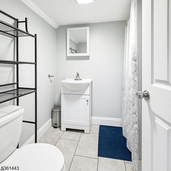 276 5th Ave, Paterson City, NJ 07524 - bathroom featuring toilet, vanity, baseboards, tile patterned floors, and crown molding