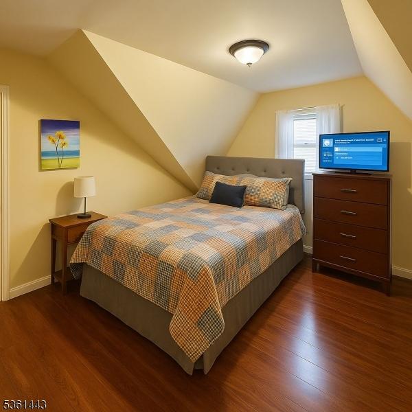 276 5th Ave, Paterson City, NJ 07524 - bedroom featuring dark wood-style floors, lofted ceiling, and baseboards