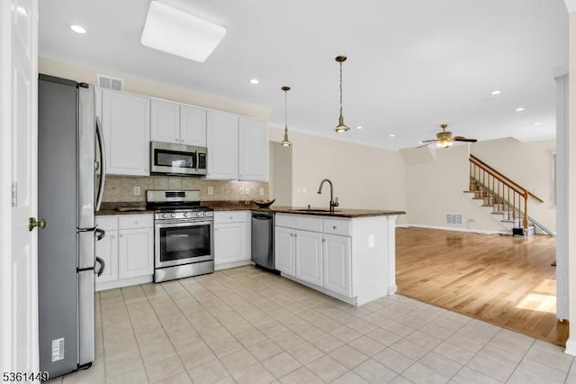 9 Mcgovern Ct, Bridgewater Twp, NJ 08807 - kitchen featuring appliances with stainless steel finishes, dark countertops, a peninsula, decorative backsplash, and recessed lighting