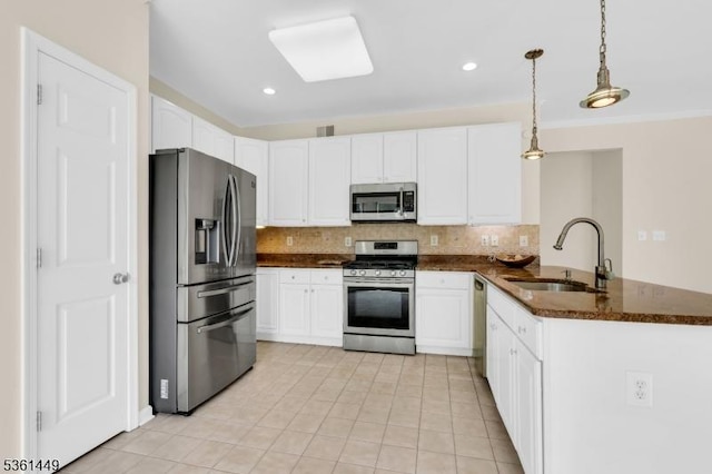 9 Mcgovern Ct, Bridgewater Twp, NJ 08807 - kitchen featuring stainless steel appliances, tasteful backsplash, a peninsula, white cabinetry, and light tile patterned floors