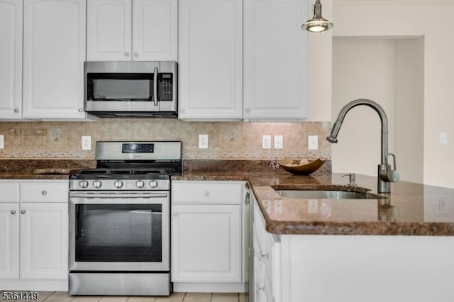 9 Mcgovern Ct, Bridgewater Twp, NJ 08807 - kitchen featuring stainless steel appliances, dark stone countertops, white cabinets, tasteful backsplash, and a peninsula