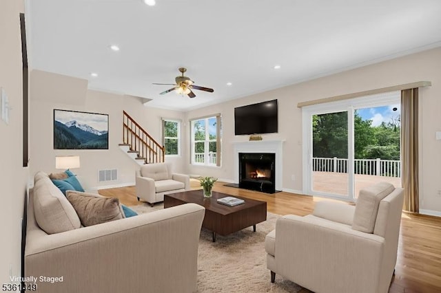 9 Mcgovern Ct, Bridgewater Twp, NJ 08807 - living area with light wood-type flooring, stairway, a premium fireplace, recessed lighting, and a ceiling fan