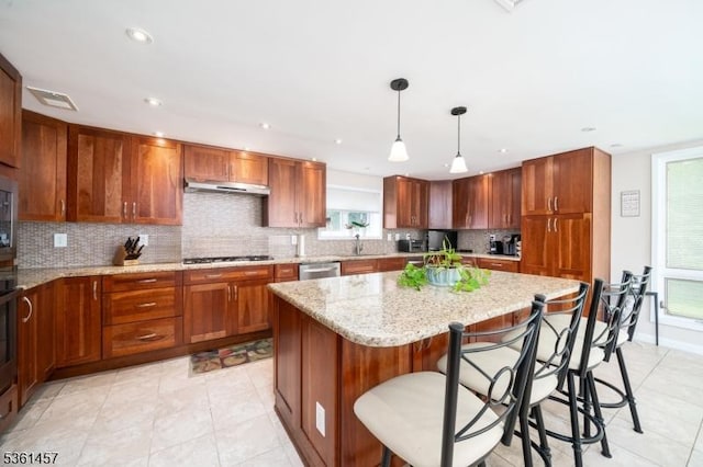 32 Fairway Ave, West Orange Twp, NJ 07052 - kitchen with decorative backsplash, a kitchen island, brown cabinets, light stone counters, and recessed lighting