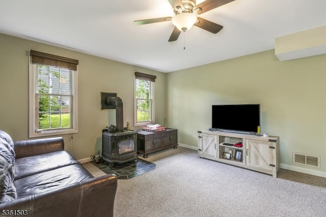 1730 Arrowbrook Dr, Bridgewater Twp, NJ 08836 - living area with a wood stove, healthy amount of natural light, a ceiling fan, and carpet flooring