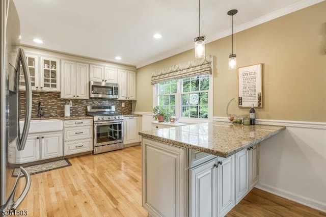 1730 Arrowbrook Dr, Bridgewater Twp, NJ 08836 - kitchen with stainless steel appliances, a peninsula, light wood finished floors, decorative backsplash, and light stone countertops
