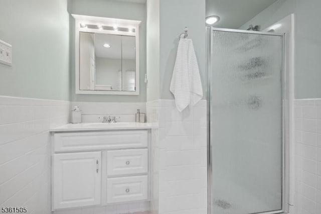 52 Hawthorne Ave, Springfield Twp, NJ 07081 - bathroom featuring vanity, a shower stall, wainscoting, and tile walls