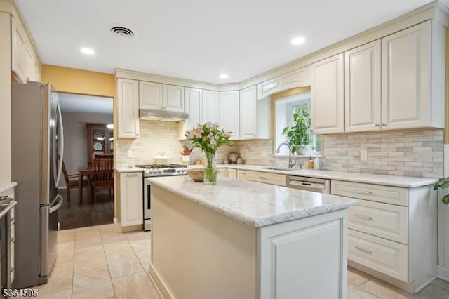 52 Hawthorne Ave, Springfield Twp, NJ 07081 - kitchen featuring appliances with stainless steel finishes, a sink, under cabinet range hood, a kitchen island, and decorative backsplash