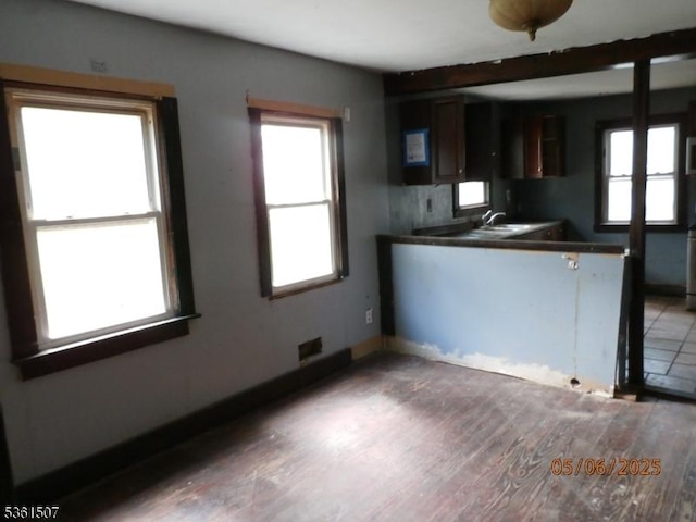 272 Lenox Pl, Franklin Twp, NJ 08873 - kitchen with dark countertops, wood finished floors, a peninsula, baseboards, and a sink