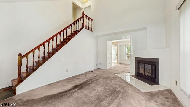 301 Smithwold Rd, Franklin Twp, NJ 08873 - unfurnished living room with stairway, a towering ceiling, a fireplace with flush hearth, and carpet