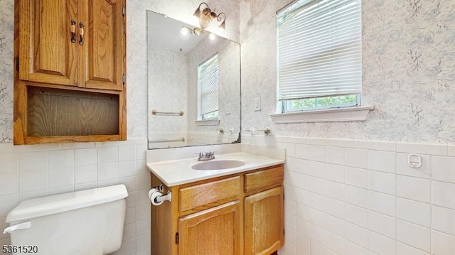 301 Smithwold Rd, Franklin Twp, NJ 08873 - bathroom with tile walls, wallpapered walls, toilet, vanity, and a wainscoted wall
