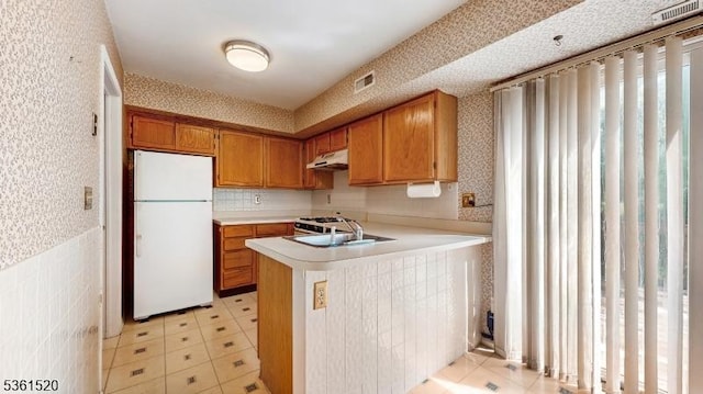 301 Smithwold Rd, Franklin Twp, NJ 08873 - kitchen with freestanding refrigerator, under cabinet range hood, wallpapered walls, a sink, and light countertops