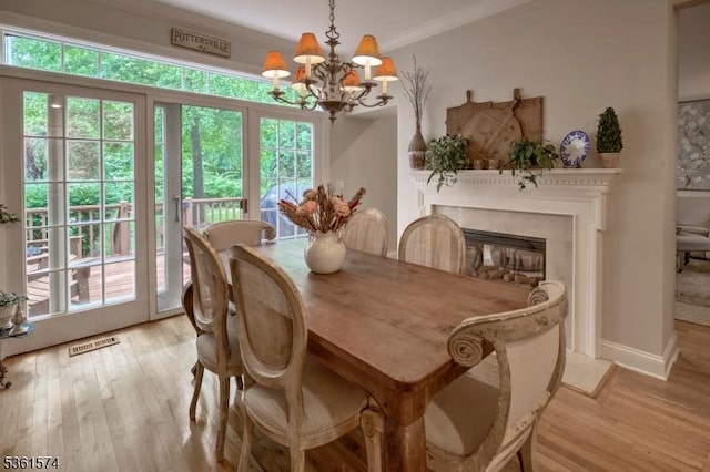 302 Lindabury Ln, Tewksbury Twp, NJ 07979 - dining area with a chandelier, light wood-style flooring, crown molding, and a glass covered fireplace