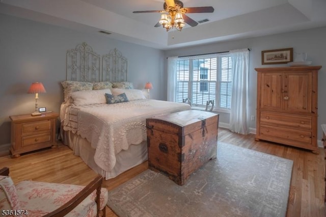 302 Lindabury Ln, Tewksbury Twp, NJ 07979 - bedroom featuring a tray ceiling, light wood-style flooring, and a ceiling fan