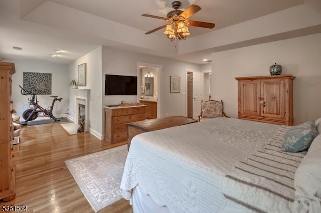 302 Lindabury Ln, Tewksbury Twp, NJ 07979 - bedroom with light wood-style flooring, a glass covered fireplace, ceiling fan, and ensuite bath