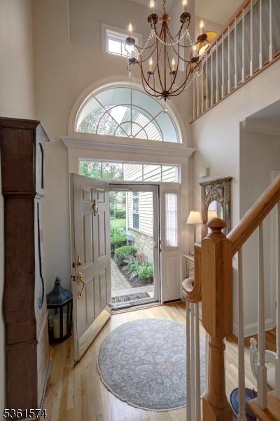 302 Lindabury Ln, Tewksbury Twp, NJ 07979 - foyer entrance featuring a chandelier, a towering ceiling, light wood-type flooring, and stairs