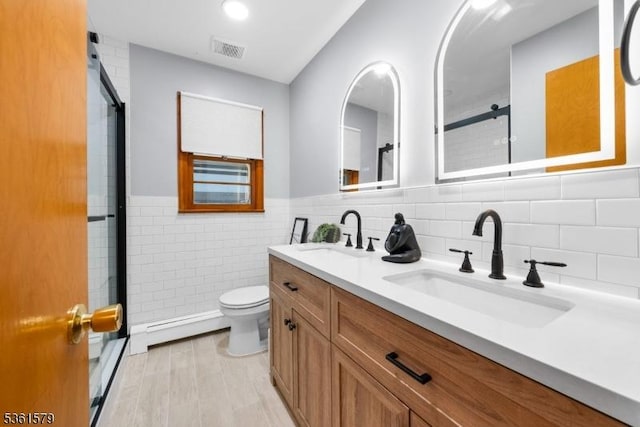 379 Washington Ave, Rutherford Boro, NJ 07070 - bathroom with a shower stall, double vanity, a baseboard radiator, toilet, and tile walls